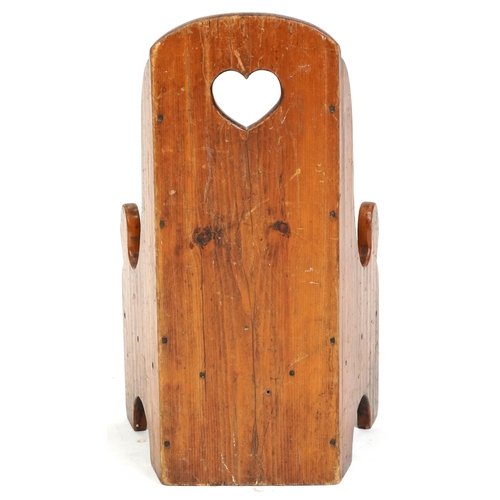 2132 - An early 20th century pine child's chair, the back pierced with a heart, raised on bracket feet, 61c... 