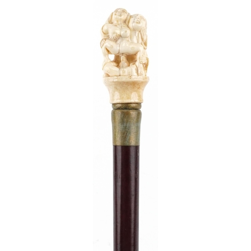 407 - A hardwood walking stick with a carved bone erotic handle, 90cm in length.