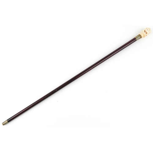 407 - A hardwood walking stick with a carved bone erotic handle, 90cm in length.