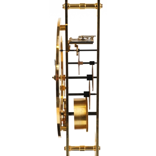 489 - A modern brass skeleton clock in the form of the Eiffel Tower, housed in a glass display case, havin... 