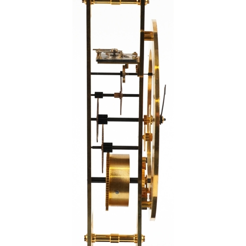 489 - A modern brass skeleton clock in the form of the Eiffel Tower, housed in a glass display case, havin... 