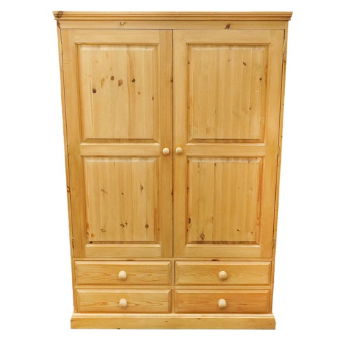 2166 - A modern pine two section wardrobe, the panelled doors raised on a plinth base, 183cm H x 122cm W x ... 