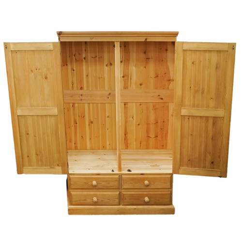 2166 - A modern pine two section wardrobe, the panelled doors raised on a plinth base, 183cm H x 122cm W x ... 