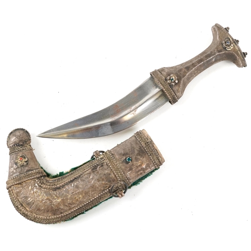 125 - A Middle Eastern white metal jambiya curved edged blade dagger, early 20th century, with engraved de... 