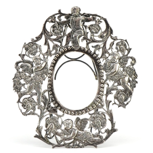 603 - An early 20th century unmarked silver portrait miniature frame pierced and embossed with Putti among... 