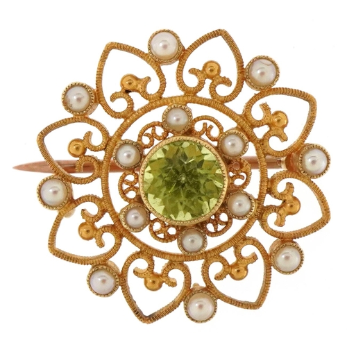 3066 - An Edwardian 15ct gold peridot and seed pearl open work brooch, 2.3cm in diameter, 4.7g.