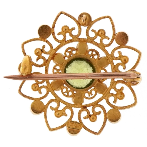 3066 - An Edwardian 15ct gold peridot and seed pearl open work brooch, 2.3cm in diameter, 4.7g.