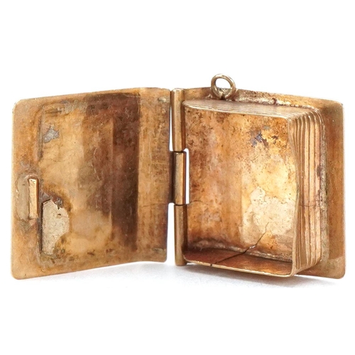 3402 - A 9ct gold and enamel opening charm in the form of a book, 1.5cm high, 1.9g.