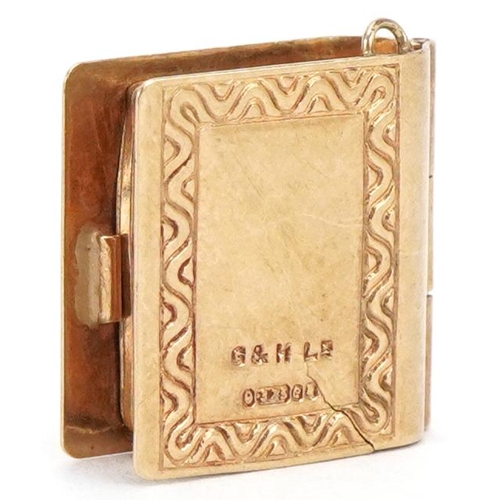 3402 - A 9ct gold and enamel opening charm in the form of a book, 1.5cm high, 1.9g.