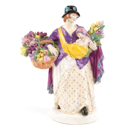 A Chelsea pottery figure of a female holding a baby and flowers, dated 1921 to the base, 26cm high.