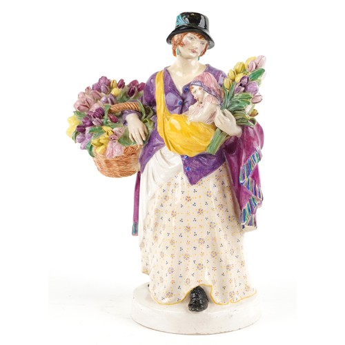  A Chelsea pottery figure of a female holding a baby and flowers, dated 1921 to the base, 26cm high.