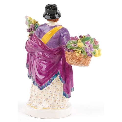  A Chelsea pottery figure of a female holding a baby and flowers, dated 1921 to the base, 26cm high.