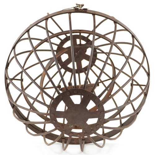 555 - An antique wrought iron hanging candle gimbal cage, approximately 46cm in diameter