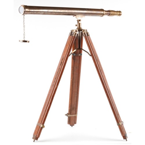 1556 - A floor standing brass telescope with adjustable tripod base, the telescope 100cm in length.