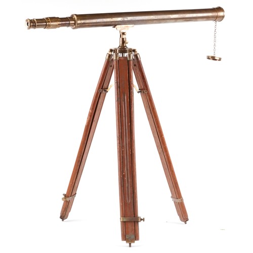 1556 - A floor standing brass telescope with adjustable tripod base, the telescope 100cm in length.