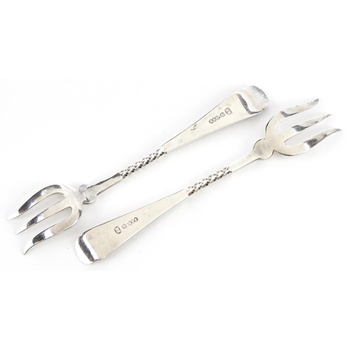 2587 - A pair of floral engraved silver plated pickle forks housed in a velvet and silk lined fitted case, ... 