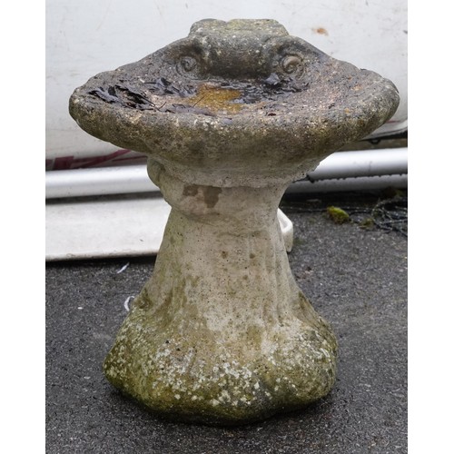 2179 - A 20th century concrete and cast composition scallop shell birdbath raised on a naturalistic pedesta... 