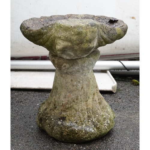 2179 - A 20th century concrete and cast composition scallop shell birdbath raised on a naturalistic pedesta... 