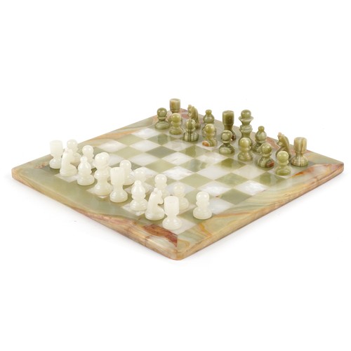 1148 - A carved green onyx chess set with board, the board 40cm x 40cm.