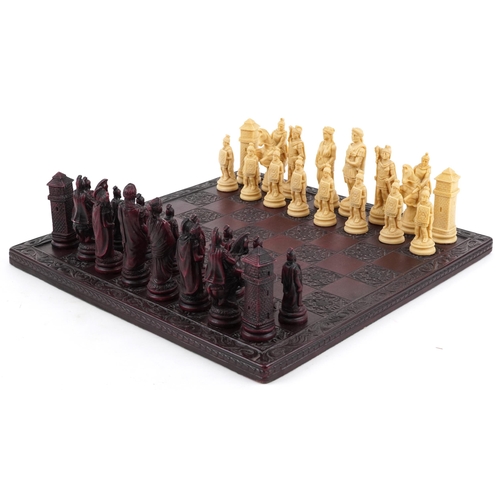 1041 - A late 20th century wax chess set, the king 11cm high, together with a stained and carved hardwood b... 
