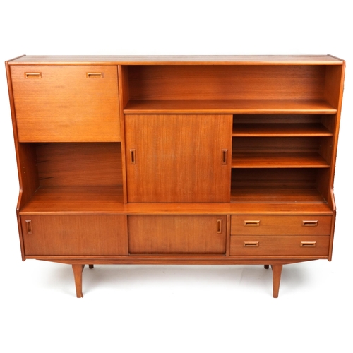 A mid 20th century teak side cabinet fitted with open shelves, sliding door and drawers, on tapering legs, 143cm H x 183cm W x 42cm D.