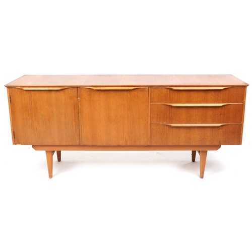 A mid 20th century teak sideboard fitted with three drawers and and cupboards raised on tapering legs, 74cm H x 168cm W x 42cm D.