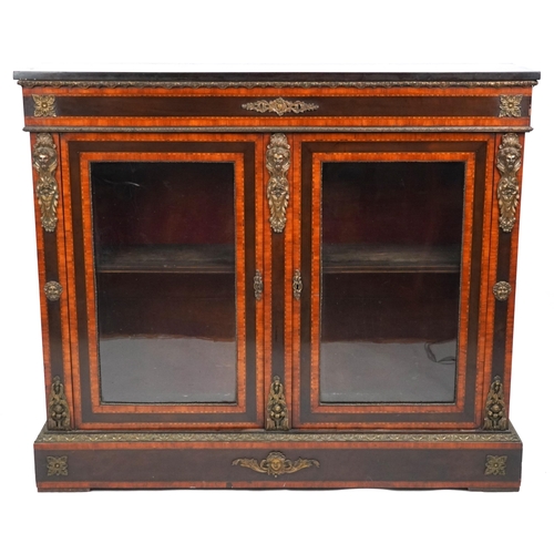 A mid Victorian ebonised and satinwood crossbanded two door pier cabinet with gilt metal mounts, the glazed doors on a plinth base, 117cm H x 136cm W x 35cm D.