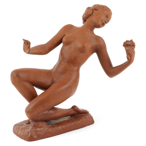 An Art Deco Goldschneider Vienna terracotta sculpture of a female nude by Josef Schuster modelled holding a bouquet of flowers, signature to base, 35cm high.