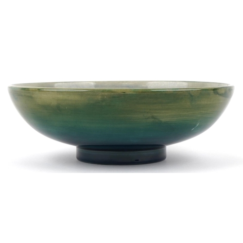 71 - A Moorcroft pottery fruit bowl hand painted with flowers, signed to the base, 24cm in diameter.