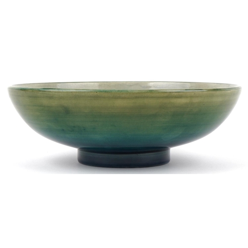 71 - A Moorcroft pottery fruit bowl hand painted with flowers, signed to the base, 24cm in diameter.