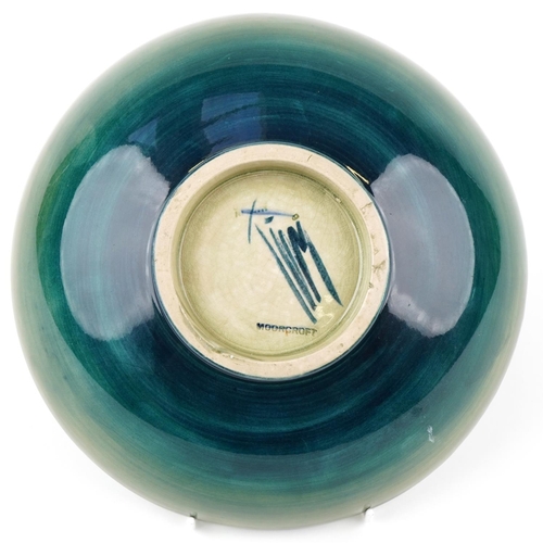 71 - A Moorcroft pottery fruit bowl hand painted with flowers, signed to the base, 24cm in diameter.