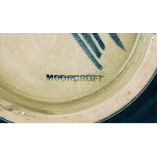 71 - A Moorcroft pottery fruit bowl hand painted with flowers, signed to the base, 24cm in diameter.