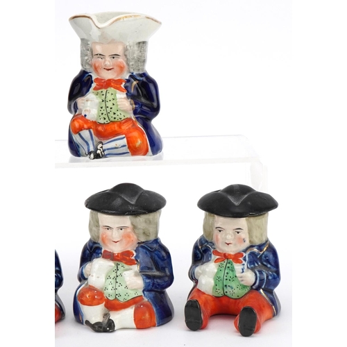 210 - Six Victorian Staffordshire pottery figures comprising three condiment pots and covers, a Toby milk ... 