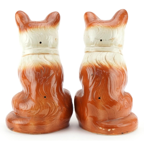 220 - A pair of large Staffordshire pottery cats with glass eyes, 32cm high.