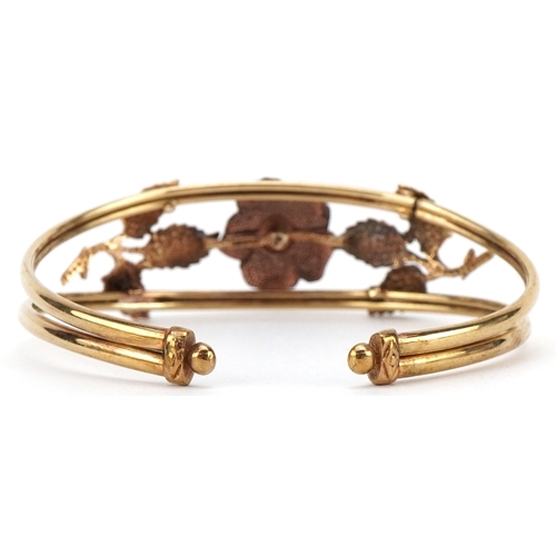 3001 - A 9ct two tone gold naturalistic rose design bangle, 9cm wide, 13.5g.