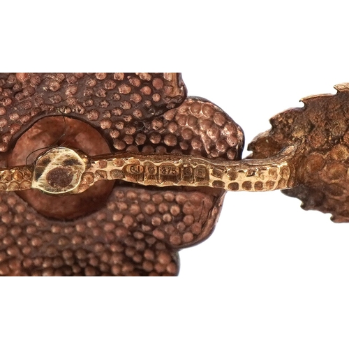 3001 - A 9ct two tone gold naturalistic rose design bangle, 9cm wide, 13.5g.