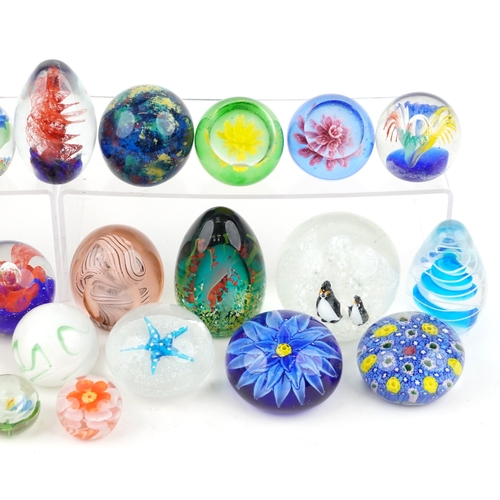 A collection of colourful glass paperweights, the largest 9cm high.
