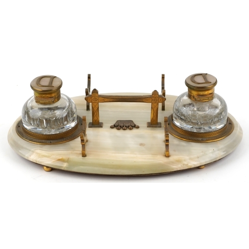 10 - An early 20th century onyx and gilt metal mounted desk stand fitted with two cut glass inkwells, eac... 