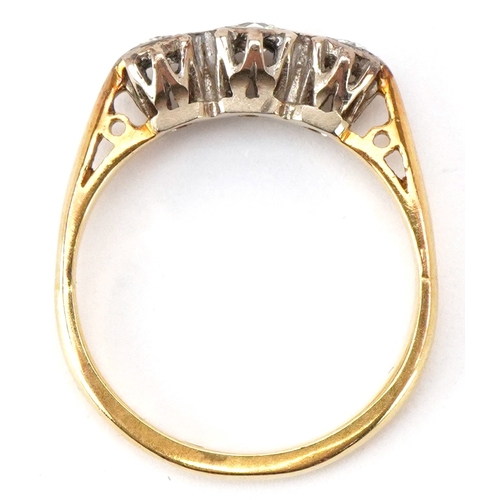 3026 - An 18ct diamond three stone ring, size L, 3.3g.