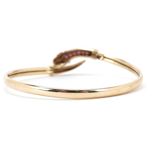3055 - A 9ct gold and pink spinel bracelet in the form of a serpent, 6cm in diameter, 7.4g.