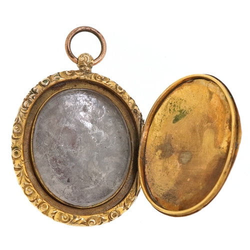 3010A - A large antique gilt metal locket with floral engraved decoration, 6.2cm high, 29.0g.