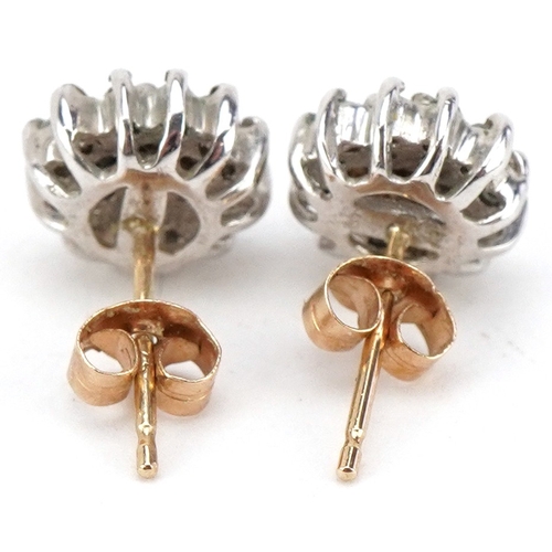 3040 - A pair of 9ct gold diamond three tier cluster stud earrings, 8.2mm in diameter, total 1.6g.