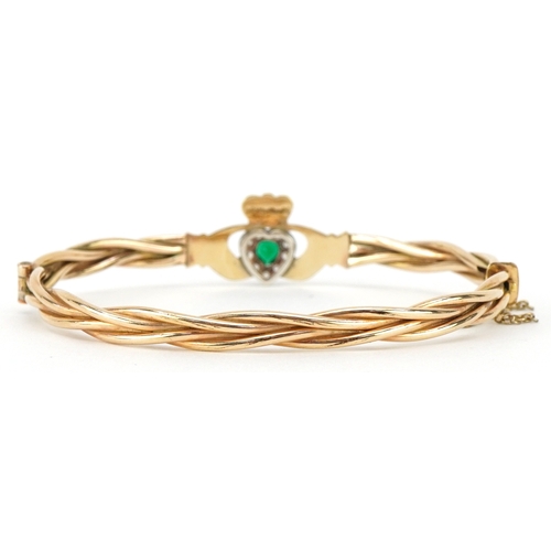 3029 - A gold plated emerald and white stone Claddagh hinged bangle, 6cm wide, 12.2g.