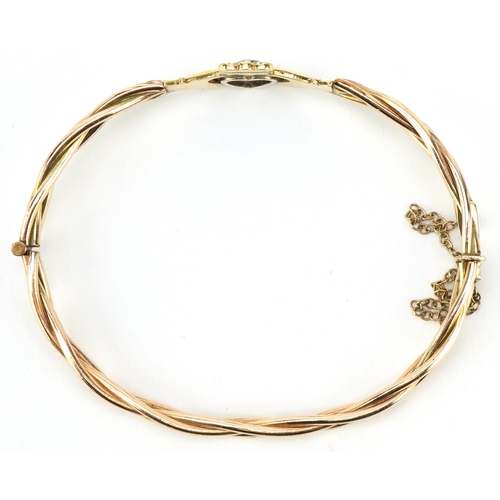 3029 - A gold plated emerald and white stone Claddagh hinged bangle, 6cm wide, 12.2g.