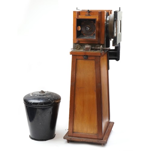 A Victorian mahogany floor standing studio camera with a hinged bullseye lens 22cm in diameter, together with plates, lighting unit and various spare parts, overall 135cm high.