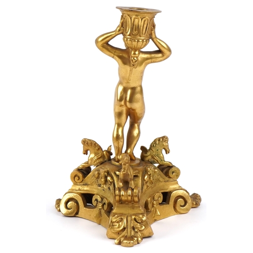 20 - An early 20th century gilt bronze and metal candlestick in the form of a young boy, raised on a trif... 