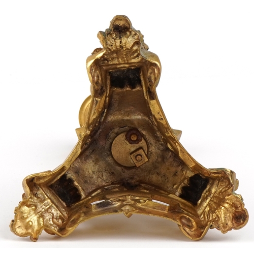 20 - An early 20th century gilt bronze and metal candlestick in the form of a young boy, raised on a trif... 