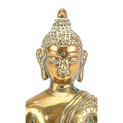 43 - A Tibetan polished brass figure of Buddha, 15cm high.