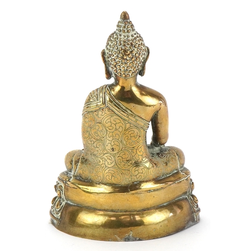 43 - A Tibetan polished brass figure of Buddha, 15cm high.