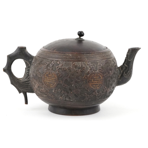 59 - A Chinese carved coconut teapot decorated with scrolling foliage, 10cm high.